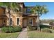 Tan two-story townhome with palm trees, brick walkway, and neatly landscaped yard at 3204 Calabria Ave # 443, Davenport, FL 33897