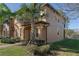 Side view of tan two-story townhome showcasing its architectural details and landscaping at 3204 Calabria Ave # 443, Davenport, FL 33897