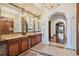 Luxurious bathroom featuring dual vanities with marble countertops and decorative mirrors at 4852 S Peninsula Dr, Ponce Inlet, FL 32127