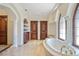 Spa-like bathroom with a soaking tub and a view from arched windows at 4852 S Peninsula Dr, Ponce Inlet, FL 32127