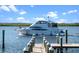 Exterior view of boat in the water next to a wood planked boat dock, under a cloudy sky at 4852 S Peninsula Dr, Ponce Inlet, FL 32127