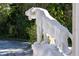 Exterior statue depicting a lion, set amidst lush landscaping along the driveway at 4852 S Peninsula Dr, Ponce Inlet, FL 32127