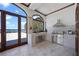 Outdoor kitchen featuring stainless steel grill, sink, tiled countertops, and a door to a waterfront patio at 4852 S Peninsula Dr, Ponce Inlet, FL 32127