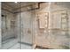 Luxurious shower with glass door, marble walls, bench, and gold towel rack at 4852 S Peninsula Dr, Ponce Inlet, FL 32127