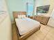 Well-lit bedroom featuring tile floors, dresser, and a mounted tv at 3001 Sea Plane Ln, Kissimmee, FL 34747