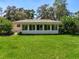Exterior view of a sunroom with a green yard and mature trees, providing a private and tranquil outdoor space at 966 N Ronald Reagan Blvd, Longwood, FL 32750