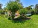 Green backyard with beautiful landscaping, flowers, plants, and a view of the sunroom at 966 N Ronald Reagan Blvd, Longwood, FL 32750