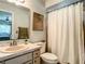 Bathroom featuring a single sink vanity, toilet, shower with curtain and a decorative mirror at 966 N Ronald Reagan Blvd, Longwood, FL 32750