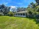 Back exterior view of the house showcasing a well-maintained lawn and screened-in porch at 966 N Ronald Reagan Blvd, Longwood, FL 32750