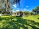 Charming home on a lush green lot with mature landscaping and a metal fence at 966 N Ronald Reagan Blvd, Longwood, FL 32750