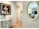 Hallway view featuring wood floors, elegant table with art and a decorative mirror that reflects the bright living spaces at 966 N Ronald Reagan Blvd, Longwood, FL 32750