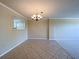Dining room featuring tiled floors, chandelier lighting, and a kitchen view through a pass-through window at 501 W Old Us Highway 441 # C201, Mount Dora, FL 32757