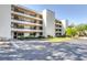 A bright, multi-story condo building with parking, landscaping, and balconies under a clear blue sky at 501 W Old Us Highway 441 # C201, Mount Dora, FL 32757