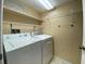 Laundry room with tile floors, overhead shelving, and a white washer and dryer at 501 W Old Us Highway 441 # C201, Mount Dora, FL 32757