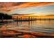 Scenic waterfront view featuring a dock under a vibrant sunset sky, perfect for lakeside living at 501 W Old Us Highway 441 # C201, Mount Dora, FL 32757