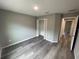 Cozy bedroom featuring modern gray walls, hardwood floors, and a convenient closet space at 75 Guava Place Dr, Ocklawaha, FL 32179