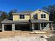 Two-story yellow house with a two-car garage. Under construction at 14 Weston Rd, Leesburg, FL 34748