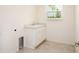 Bright laundry room featuring a built-in sink with a marble countertop and a window for natural light at 111 Addle Hill Ct, Deland, FL 32720