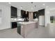 Modern kitchen with island, black cabinets, and stainless steel appliances at 3016 Kensington Ave, Davenport, FL 33837