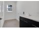 Clean laundry room with white walls and black cabinets at 3016 Kensington Ave, Davenport, FL 33837