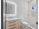 Modern bathroom featuring walk-in shower with accent tiles, wooden vanity, sink, and lighted mirror at 260 Deer Isle Dr, Winter Garden, FL 34787