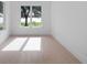 Bright bedroom featuring large windows overlooking lake, hardwood floors, and neutral wall color at 260 Deer Isle Dr, Winter Garden, FL 34787