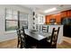 Bright dining area features a dark wood table with six chairs, adjacent to kitchen at 904 Charo Pkwy # 518, Davenport, FL 33897