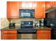 Kitchen with black appliances and wood cabinets at 904 Charo Pkwy # 518, Davenport, FL 33897