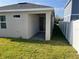 Backyard featuring a covered patio with seamless access and a well-maintained yard bordered by a white fence at 1225 Atlantic Ave, Fruitland Park, FL 34731