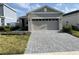 Charming one-story home featuring a two-car garage and a beautifully paved driveway and walkway at 1225 Atlantic Ave, Fruitland Park, FL 34731