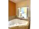 Modern bathroom featuring a large jacuzzi tub, tile surround, and a pass-through to the Primary suite at 12521 Floridays Resort Dr # 302F, Orlando, FL 32821