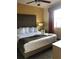 Well-lit bedroom features a plush bed with decorative towel swans, bedside table, and soft lighting at 12521 Floridays Resort Dr # 302F, Orlando, FL 32821