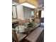 Dining area featuring a glass-top table with bench seating, stylish lighting, and a view of the living area at 12521 Floridays Resort Dr # 302F, Orlando, FL 32821