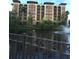 Apartment building with multiple balconies overlooking a serene pond and fountain, creating a tranquil setting at 12521 Floridays Resort Dr # 302F, Orlando, FL 32821