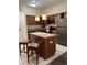 Modern kitchen featuring a center island with granite countertops, stainless appliances, and pendant lighting at 12521 Floridays Resort Dr # 302F, Orlando, FL 32821