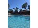 Large outdoor pool with palm trees and lounge area for relaxing at 12521 Floridays Resort Dr # 302F, Orlando, FL 32821