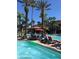 Community pool with lounge chairs and tropical palm trees at 12521 Floridays Resort Dr # 302F, Orlando, FL 32821