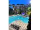 Inviting swimming pool with sun loungers, mature palms and landscaping, and night lighting at 12521 Floridays Resort Dr # 302F, Orlando, FL 32821