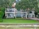 Waterfront home with balconies, mature trees, and manicured lawn at 800 W 2Nd Ave, Windermere, FL 34786