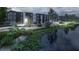 Exterior view of modern apartments overlooking a pond, framed by lush greenery and a security fence at 4424 S Texas Ave, Orlando, FL 32839