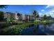 Modern apartments overlooking a tranquil pond, framed by lush greenery and a security fence at 4424 S Texas Ave, Orlando, FL 32839