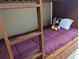 Wooden bunk bed with purple bedding in a bedroom at 13427 Blue Heron Beach Dr # 702, Orlando, FL 32821