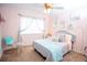 Bright bedroom featuring a comfortable bed with decorative pillows, soft pink walls, and stylish sheer curtains at 3001 Sunset Vista Blvd, Kissimmee, FL 34747