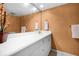 Bathroom featuring an extra-long vanity with a white countertop, gold fixtures, and a large mirror at 6254 Masters Blvd # D106, Orlando, FL 32819
