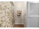 Bathroom featuring a bamboo shower curtain, two towels with palm tree accents, and a white louvered door at 6254 Masters Blvd # D106, Orlando, FL 32819