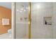 Bathroom featuring neutral tile, glass shower door, and built-in shelving for toiletries at 6254 Masters Blvd # D106, Orlando, FL 32819