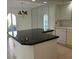 Kitchen island with a black countertop and classic chandelier, offering a stylish focal point at 6254 Masters Blvd # D106, Orlando, FL 32819