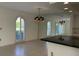 Bright living room with chandelier, tile floors, and view of the home's exterior at 6254 Masters Blvd # D106, Orlando, FL 32819