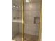 Tiled walk-in shower with glass door, built in soap dishes, and gold fixtures at 6254 Masters Blvd # D106, Orlando, FL 32819