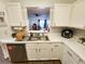 Well-lit kitchen featuring white cabinets, stainless steel appliances, and an open view to the living area at 4865 Cypress Woods Dr # 2204, Orlando, FL 32811